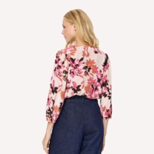 Μοντέλο φοράει γυναικεία φλοράλ μπλούζα z με μανίκια 3/4, συνδυασμένη με τζιν παντελόνι. Πίσω όψη