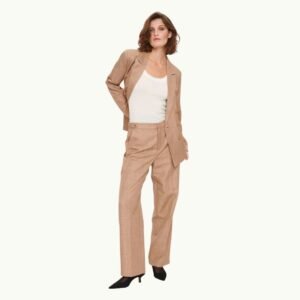 Γυναίκα φοράει μπεζ/καφέ κοστούμι με σακάκι και παντελόνι, συνδυασμένο με λευκό τοπ και μαύρες γόβες