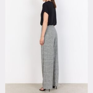 «Γυναικείο ψηλόμεσο γκρι καρό παντελόνι σε γραμμή wide leg, φωτογραφημένο από πλάγια όψη. Κατασκευασμένο από μαλακό ύφασμα με γκρι βάση και διακριτικό καρό μοτίβο, φορεμένο με μαύρο T-shirt και μαύρα πέδιλα σε ουδέτερο λευκό φόντο.»
