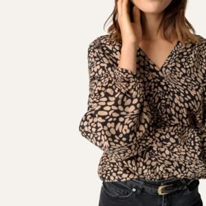 «Κοντινή λήψη μπλούζας με αφηρημένο καφέ μοτίβο σε μαύρο φόντο, V λαιμόκοψη με κουμπιά και ρευστό ύφασμα βισκόζης LENZING™ ECOVERO™, σε ουδέτερο φόντο.»