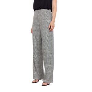 «Λεπτομερής λήψη του γκρι καρό παντελονιού σε προφίλ, που δείχνει τη ρευστή εφαρμογή του υφάσματος και τη φαρδιά γραμμή στο τελείωμα. Μαύρο μπλουζάκι και μίνιμαλ styling σε λευκό φόντο.»