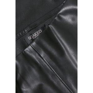 «Κοντινή λήψη στη λεπτομέρεια του μαύρου οικολογικού δέρματος και στην εσωτερική ετικέτα Soaked in Luxury στο παντελόνι.»