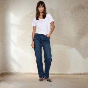 Γυναίκα φορά το τζιν SC-KIMBERLY 34-B σε σκούρο μπλε denim με straight γραμμή και πεντάτσεπο σχέδιο. Το συνδυάζει με λευκό T-shirt και zebra-print flats, σε φυσικό φόντο με απαλό φωτισμό και υφή τοίχου σε γήινους τόνους.