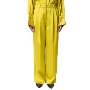 «Σατινέ κίτρινο παντελόνι σε έντονη γυαλιστερή υφή, σε στούντιο φόντο. Ίσια, wide–leg γραμμή με μπροστινές πιέτες και ψηλή μέση. Το μοντέλο φορά ασορτί σατινέ πουκάμισο με μακριά μανίκια και μεταλλικές λεπτομέρειες στις μανσέτες.»