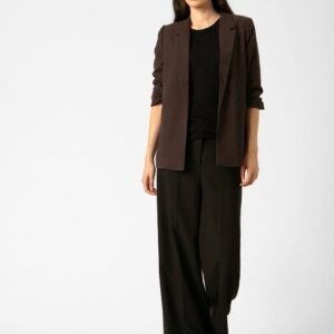 «Κοντινή λήψη ολόσωμης εμφάνισης: το μοντέλο φορά σοκολατί blazer Soaked in Luxury με μαύρη μπλούζα και μαύρο παντελόνι. Φωτογράφιση σε λευκό στούντιο.»