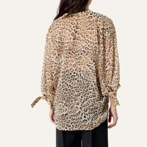 «Μοντέλο από πίσω με λεοπάρ μπλούζα Soaked in Luxury, χαλαρή εφαρμογή, μανίκια 3/4 με δεσίματα. Φόντο σε ουδέτερο μπεζ τόνο.»