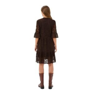 «Πίσω όψη μίντι δαντελένιου φορέματος σε deep cocoa, με ανάλαφρη εφαρμογή και καμπάνα λεπτομέρεια στα μανίκια. Το μοντέλο φοράει καφέ δερμάτινες μπότες, σε λευκό φόντο.»