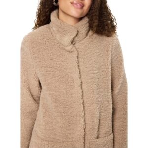 Λεπτομέρεια γυναικείου teddy παλτού με απαλή υφή, όρθιο γιακά και διακριτικό κούμπωμα σε μπεζ απόχρωση.