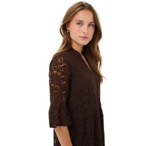 «Κοντινό πλάγιο του μίντι φορέματος από καφέ δαντέλα, που δείχνει το V-ντεκολτέ και τα διάφανα δαντελένια μανίκια 3/4. Φόντο λευκό.»