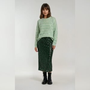 Πλεκτό πουλόβερ στο χρώμα της μέντας με χαλαρή εφαρμογή και διακριτικές ριγέ λεπτομέρειες με ελαφριά λάμψη, συνδυασμένο με πράσινη midi παγιέτα φούστα και μαύρα αρβυλάκια, φορεμένο σε ουδέτερο ανοιχτό φόντο.