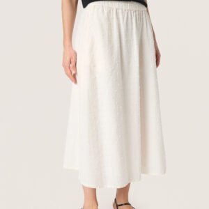 Λεπτομέρεια γυναικείας midi φούστας σε ecru με ανάγλυφη υφή και ελαστική μέση, που αναδεικνύει την απαλή πτώση του υφάσματος, σε studio φόντο.