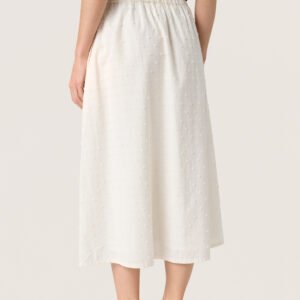 Κοντινό πλάνο σε midi φούστα ecru με ανάγλυφα dots και ελαστική μέση, που δείχνει την υφή και την εφαρμογή του υφάσματος.