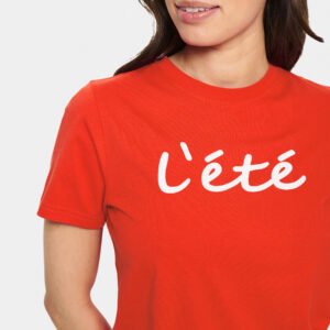 Γυναικείο κόκκινο t-shirt με στάμπα “L’été”, φορεμένο σε μοντέλο, με φυσική εφαρμογή και minimal styling σε ουδέτερο φόντο