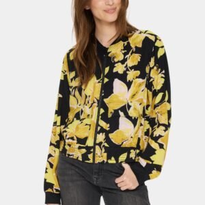 Γυναίκα φορά bomber jacket Saint Tropez με χρυσοκίτρινο floral print και μαύρο denim παντελόνι, σε relaxed urban chic styling με ανοιχτό γκρι studio φόντο.