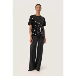Γυναικείο total black outfit με μπλούζα Soaked in Luxury με παγιέτες και μαύρο tailored παντελόνι, styled σε minimal studio περιβάλλον.